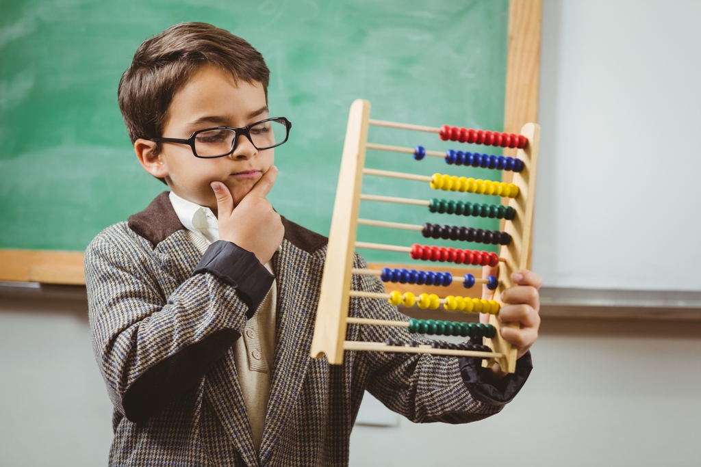 Pupil dressed up as teacher holding abacus in a classroom