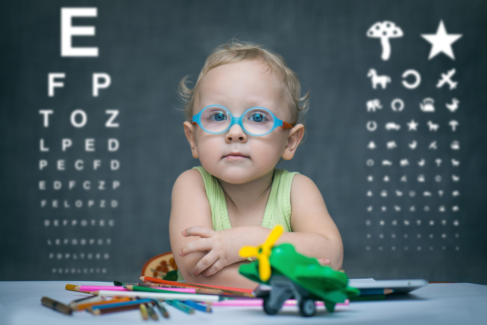 Smart,Kid,Sitting,At,A,Table,With,Glasses