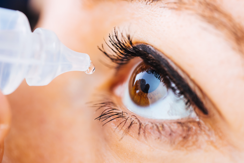 Macro,Pose,Of,Woman,Dripping,Eye,With,Eyes,Drops