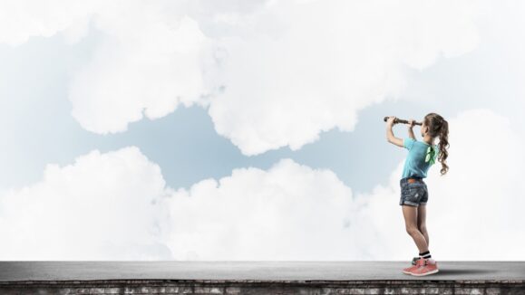 Cute kid girl standing on house roof and looking in spyglass