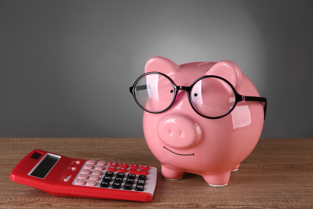 Piggy,Bank,In,Glasses,With,Calculator,On,Grey,Background