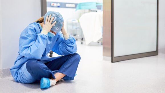 Exhausted,Doctor,Or,Nurse,Sits,In,Front,Of,The,Operating