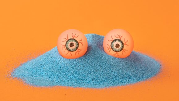 Creative,Concept,Of,Blue,Sand,Creature,With,Eyes,On,Orange